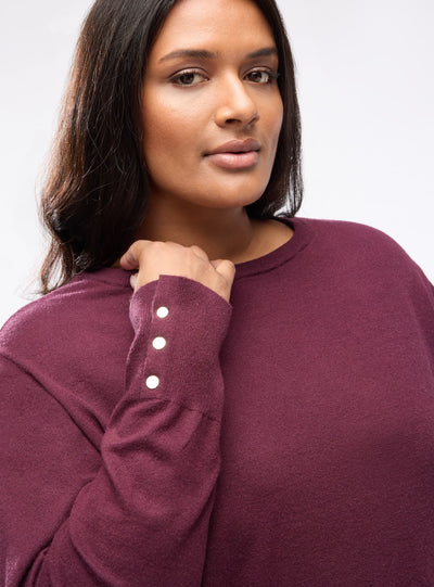 Pull uni avec boutons aux poignets