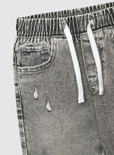 Jeans jogger da bambino con strappi e coulisse